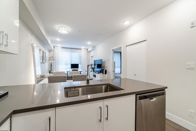 Kitchen featuring dishwasher, open floor plan, dark countertops, and white cabinetry | Image 17
