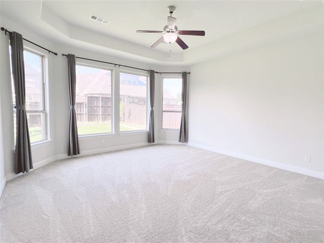 Spare room with a raised ceiling, light colored carpet, and ceiling fan | Image 21