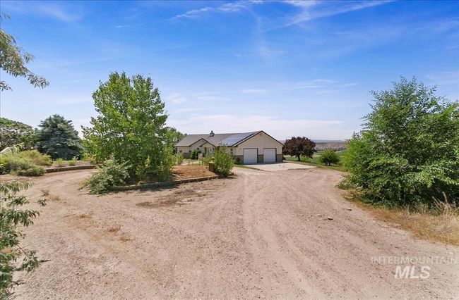 View of front facade with driveway, solar panels, and a garage | Image 47
