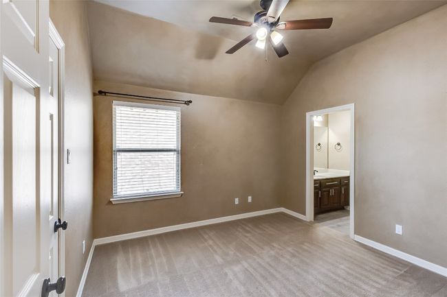 Unfurnished bedroom featuring light carpet, baseboards, lofted ceiling, and connected bathroom | Image 31