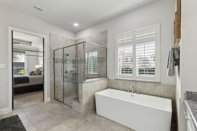 Ensuite bathroom with a soaking tub, a stall shower, tile patterned floors, and recessed lighting | Image 19