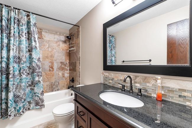 Bathroom featuring tasteful backsplash, shower / bath combination with vanity | Image 25