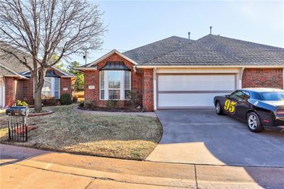 Ranch-style house featuring a garage and a front lawn | Image 1