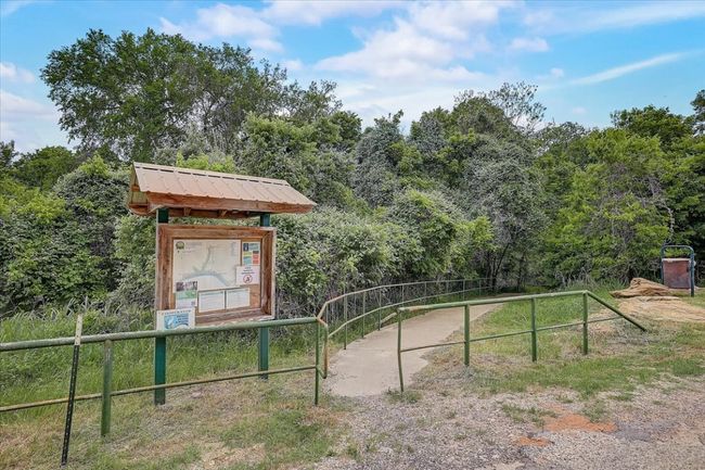 View of property's community featuring a wooded view and fence | Image 17
