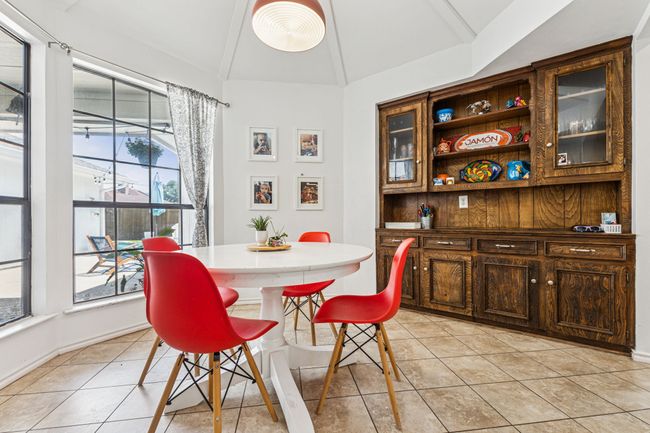 Dining room with lofted ceiling, light tile patterned floors, and baseboards | Image 10