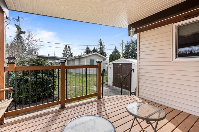 Wooden terrace featuring an outbuilding and a storage shed | Image 24