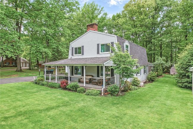 Charming two-story home with a spacious wrap-around porch, perfect for enjoying the serene surroundings. | Image 5