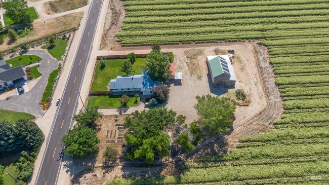 Aerial view of sparsely populated area with rows of crops | Image 49