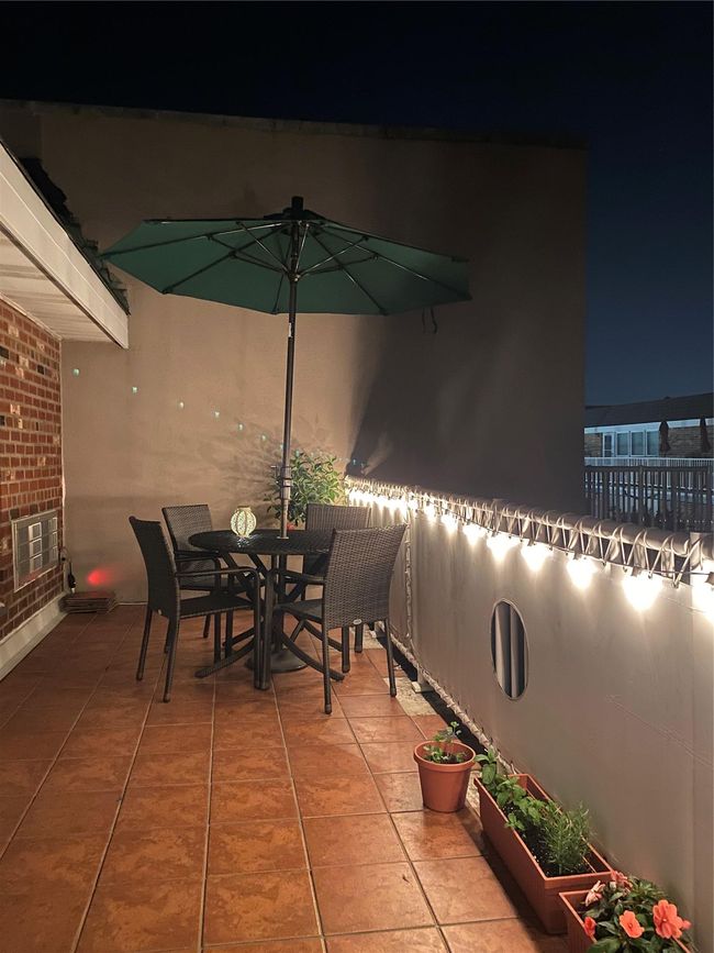 Patio at night with outdoor dining area and fence | Image 17