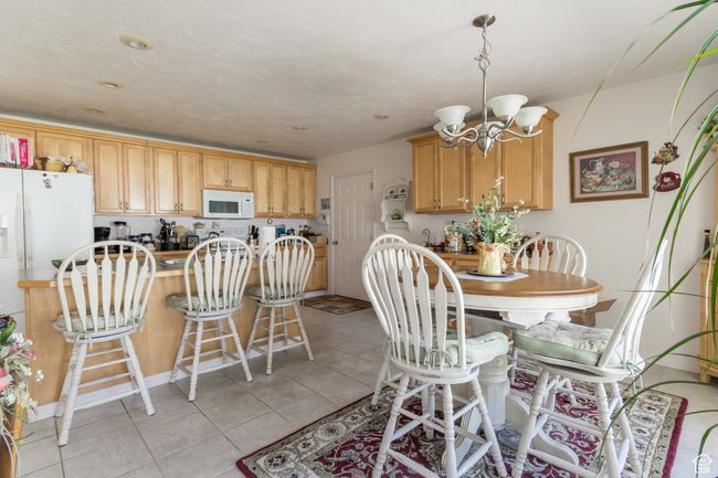 Dining space featuring light tile patterned floors and a chandelier | Image 26