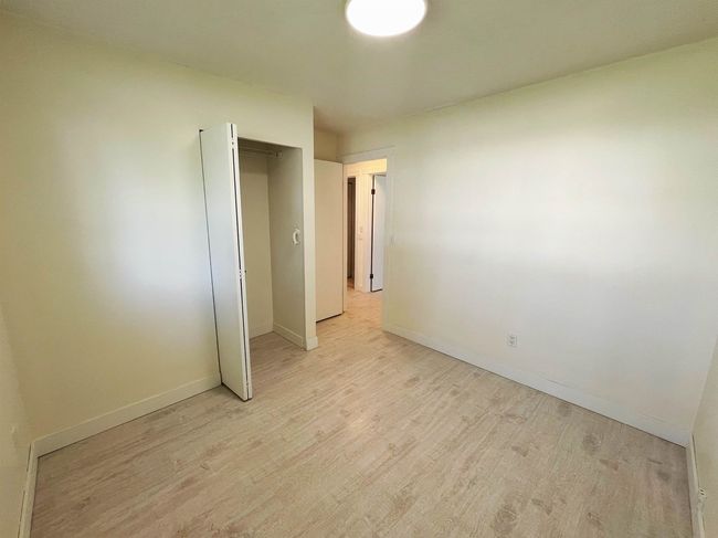 Unfurnished bedroom featuring light wood-style flooring and a closet | Image 6
