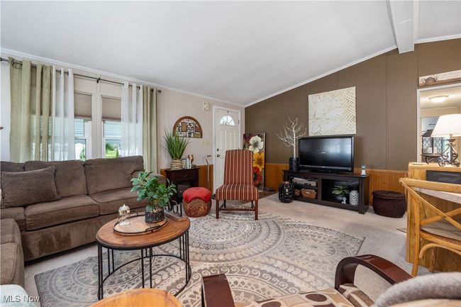 Living room featuring carpet floors, crown molding, a decorative wall, and wainscoting | Image 19