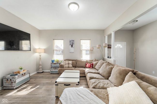 living area featuring wood finished floors, decorative columns, and baseboards | Image 4