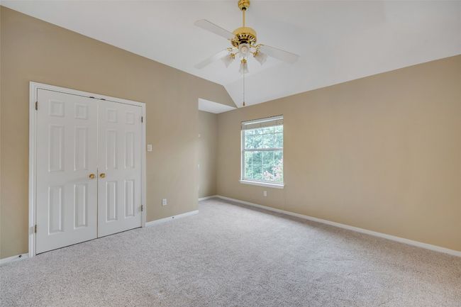 Unfurnished bedroom with carpet, a closet, vaulted ceiling, and ceiling fan | Image 34