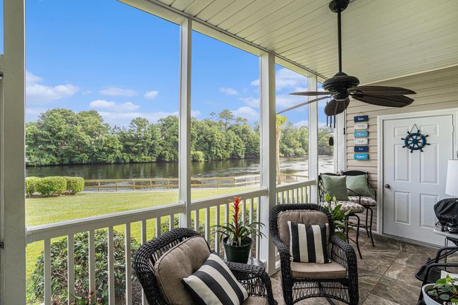 Sunroom with a water view, a ceiling fan, and plenty of natural light | Image 19