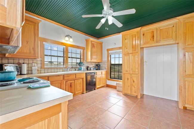 Kitchen featuring dishwasher, tasteful backsplash, light countertops, and light tile patterned flooring | Image 14