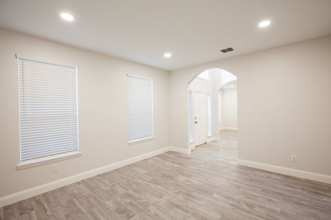 Spare room featuring arched walkways, light wood-style flooring, and recessed lighting | Image 6
