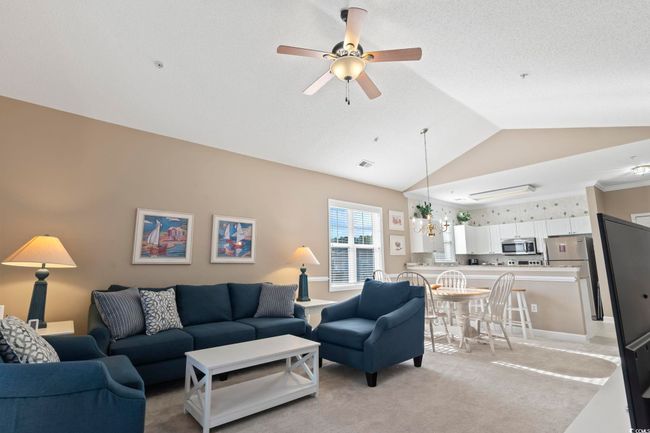 Living room with vaulted ceiling, ceiling fan, and light carpet | Image 17