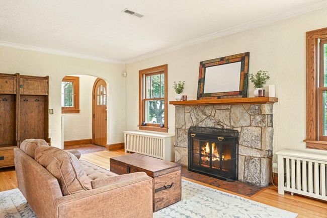 Cozy up to the wood burning fireplace in the sunny front living room | Image 4