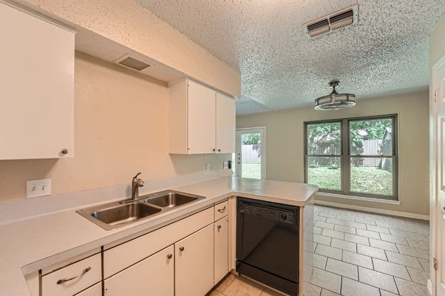 Spacious kitchen with abundant lighting. | Image 4