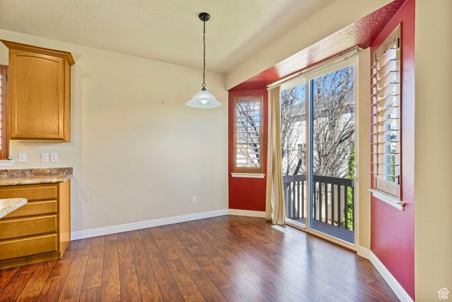 Unfurnished dining area featuring baseboards, dark wood-type flooring, and a textured ceiling | Image 11