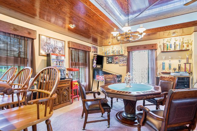 Carpeted dining space with wooden ceiling, a chandelier, healthy amount of natural light, and vaulted ceiling | Image 16