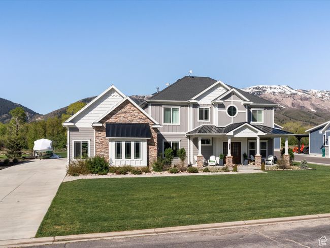 Craftsman house featuring a standing seam roof, a mountain view, a porch, and stone siding | Image 45