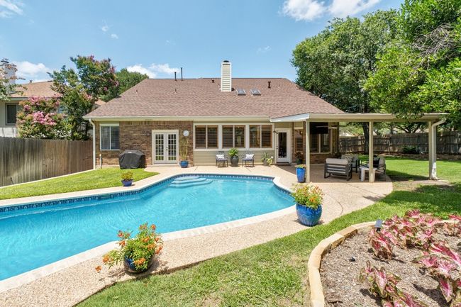 View of swimming pool with grilling area, french doors, a fenced backyard, a patio, and an outdoor living space | Image 24