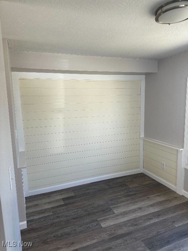 Empty room featuring a textured ceiling and dark hardwood / wood-style flooring | Image 5