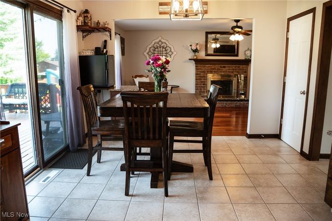 Dining area featuring healthy amount of natural light, ceiling fan, a fireplace, and light tile patterned floors | Image 22