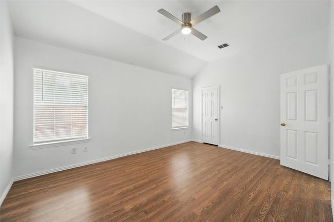 Spare room featuring a ceiling fan, dark wood-type flooring, baseboards, and lofted ceiling | Image 20