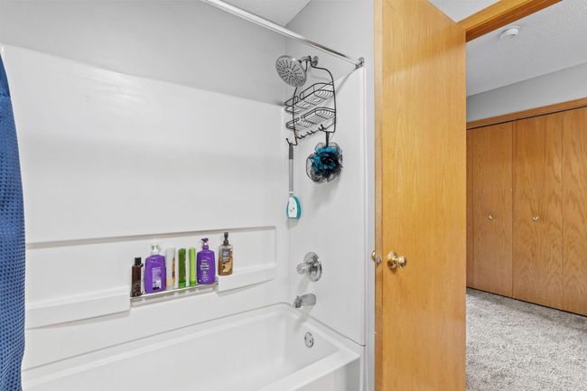 Full bath with tub/shower combo and built-in shelving for convenient storage. | Image 24