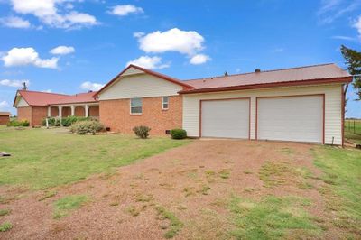 View of front facade with a garage and a front lawn | Image 2