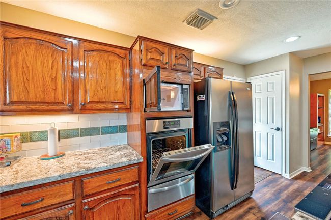 Discover culinary convenience with two gas ovens—one elegantly built into the wall and another seamlessly integrated into the island. | Image 14