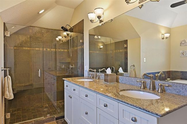 Double sink vanity with a spacious, modern shower. | Image 23