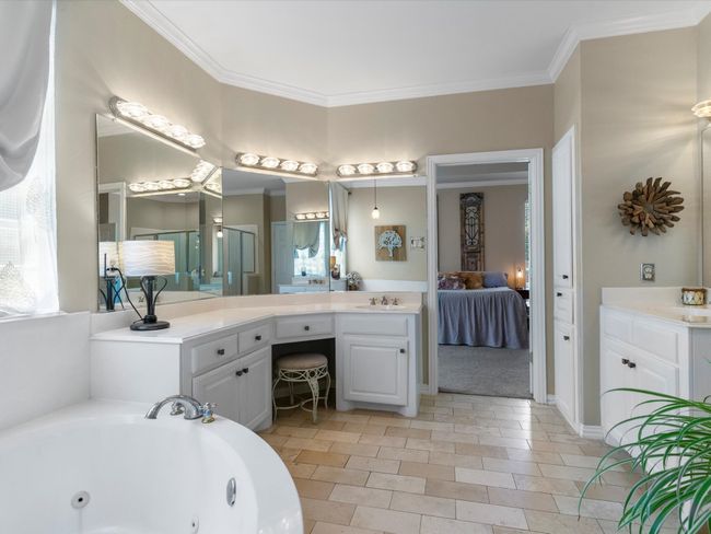 Ensuite bathroom with vanity, a whirlpool tub, ornamental molding, a shower stall, and tile patterned floors | Image 20