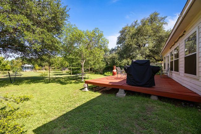 View of grassy yard featuring a wooden deck | Image 25