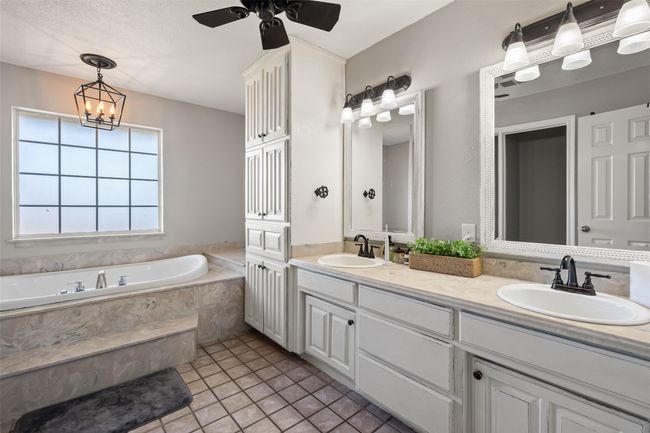 Full bath with ceiling fan, a garden tub, a sink, and double vanity | Image 16