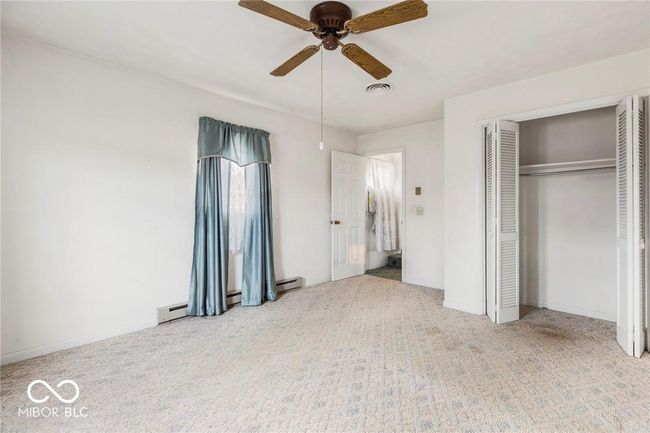 unfurnished bedroom with carpet flooring, a closet, and a ceiling fan | Image 29