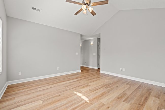 Empty room featuring a ceiling fan, light wood-style floors, and high vaulted ceiling | Image 10