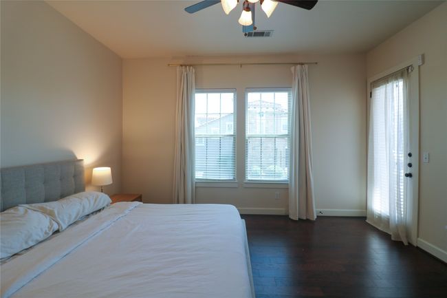 Bedroom with visible vents, baseboards, multiple windows, and dark wood-style floors | Image 16