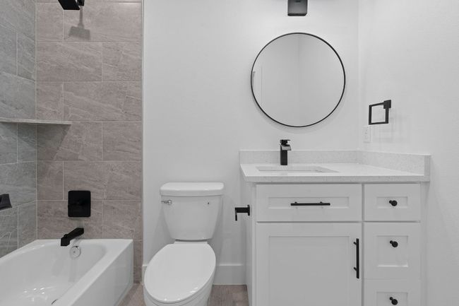 Bathroom with baseboards, toilet, shower / bathing tub combination, and vanity | Image 19