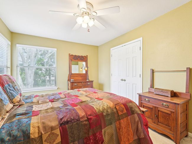 Bedroom featuring multiple windows, light colored carpet, and a ceiling fan | Image 29