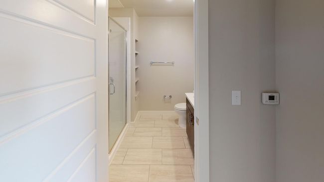 Bathroom featuring vanity, toilet, tile patterned floors, and a shower with shower door | Image 4