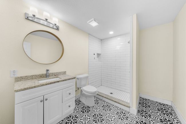 Full bathroom featuring vanity, toilet, tiled shower, baseboards, and tile patterned flooring | Image 13