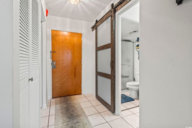 Large Tiled Entry ... shows entry to Bathroom via Glass Panelled Sliding Door | Image 5