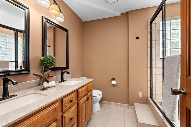 Updated Owners' Suite bath with dual-sink vanity and tile shower. | Image 20