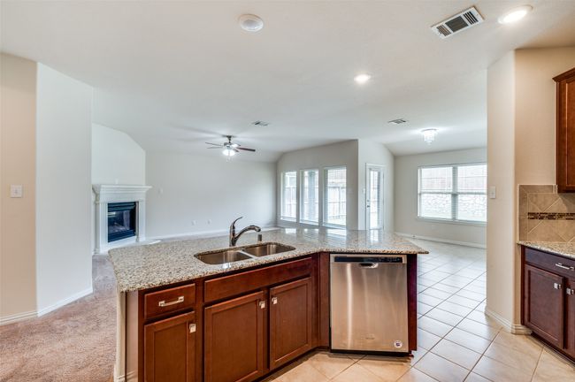 Kitchen with dishwasher, open floor plan, ceiling fan, and a sink | Image 10