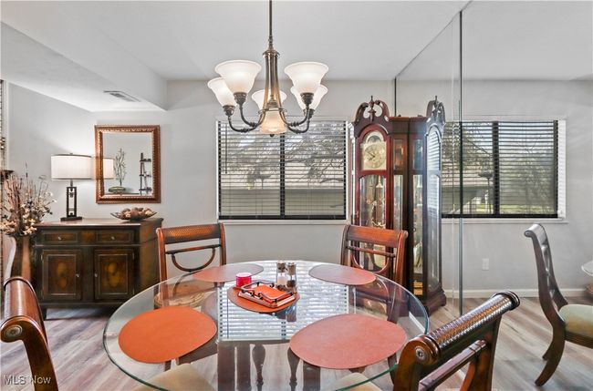 Dining room featuring visible vents, wood finished floors, a notable chandelier, and baseboards | Image 7