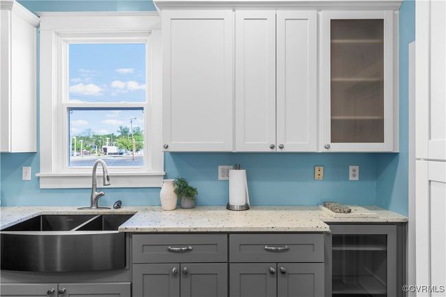 Kitchen with gray cabinets, light stone counters, a sink, and glass insert cabinets | Image 16